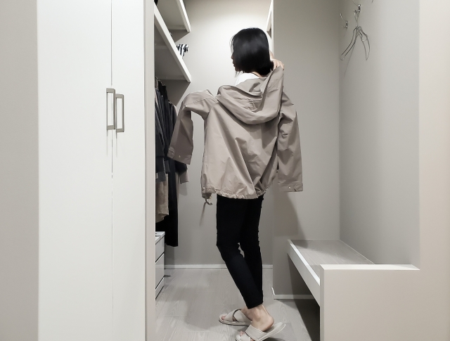 外で着ていた上着を脱ぐ写真
