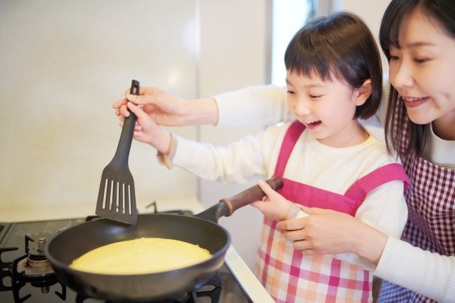 子育て世帯の親子で料理する様子